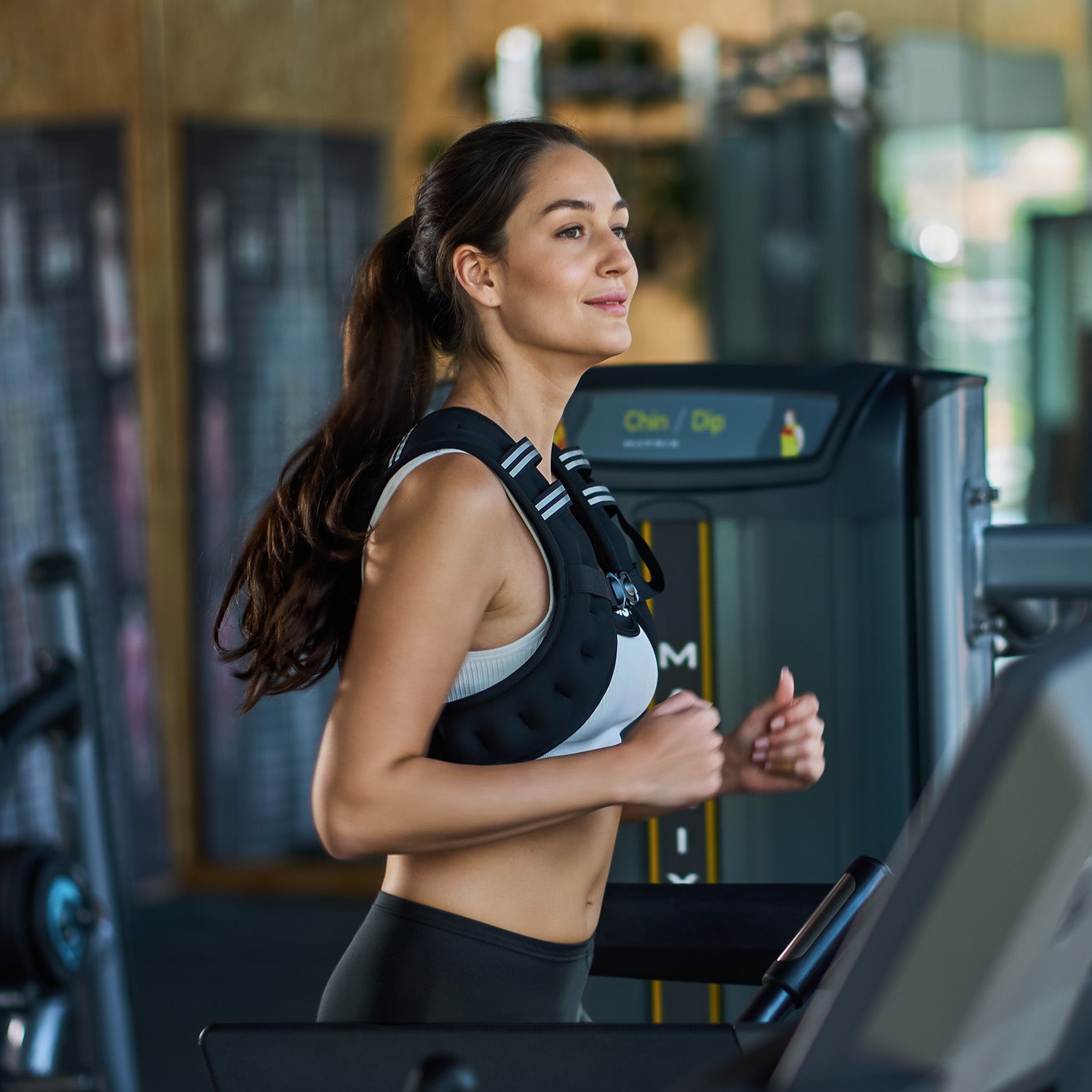 Woman running on a treadmill in a gym setting