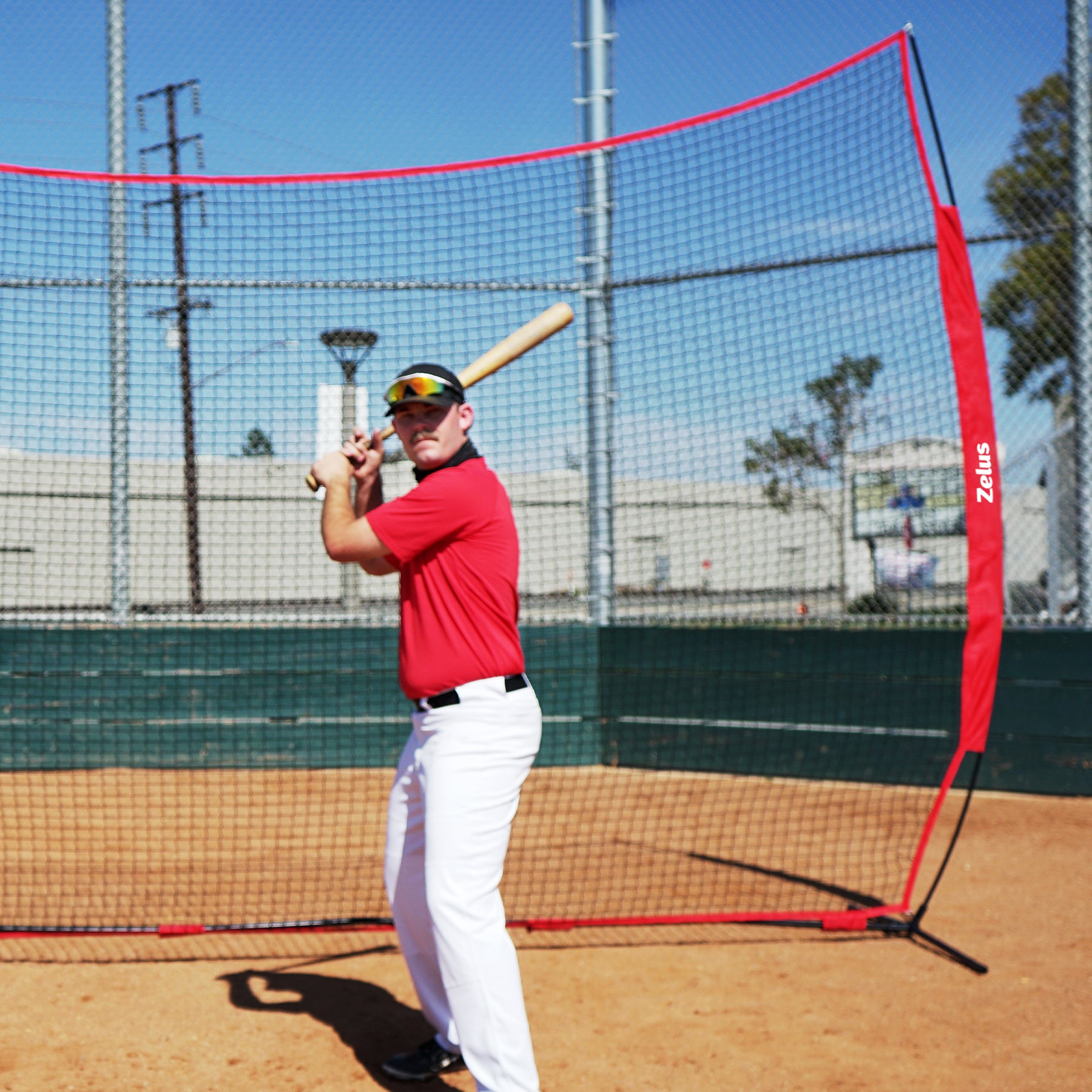 Person standing in front of a large red and black sports net 