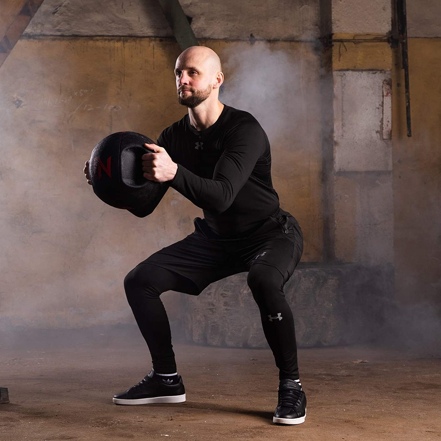 Man performing a kettlebell exercise in a gym setting
